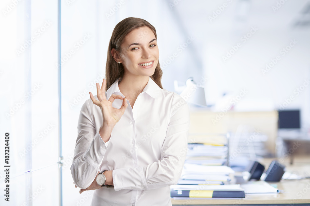 Everything is perfect at the business life. Beautiful young woman gesturing okay sign. Everything is perfect at the business life. Beautiful young woman gesturing okay sign.