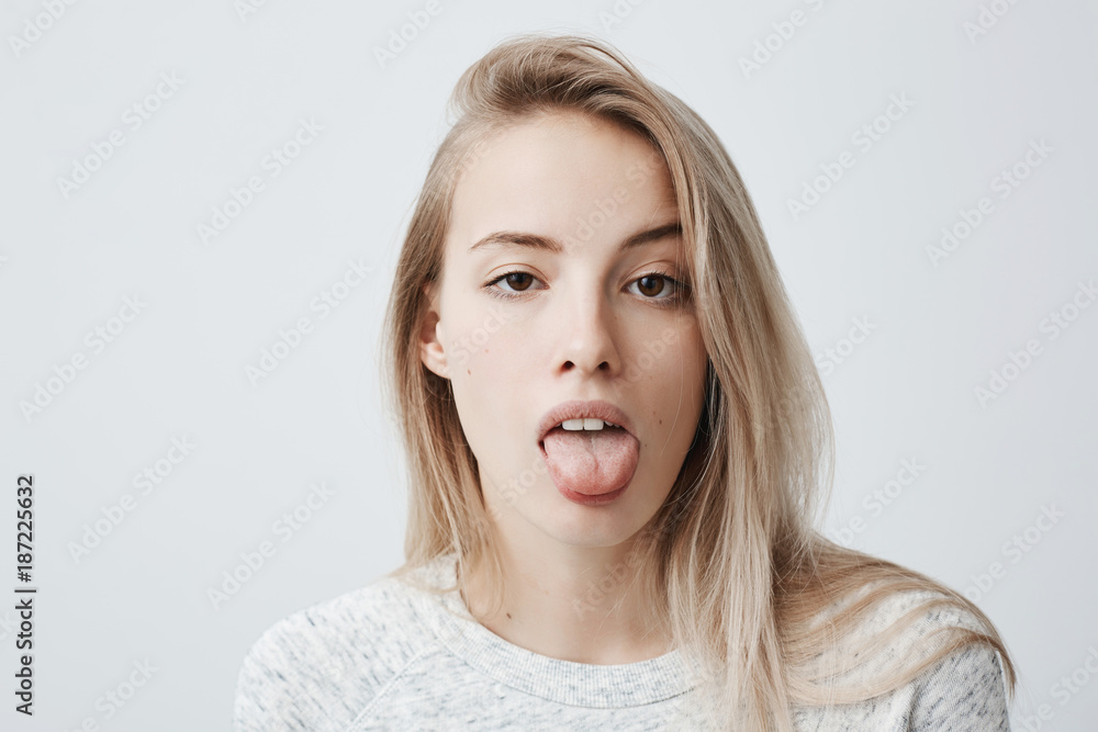 Disgusted Pretty Young Woman With Blonde Hair Sticking Out Tongue Expressing Her Dislike Or 