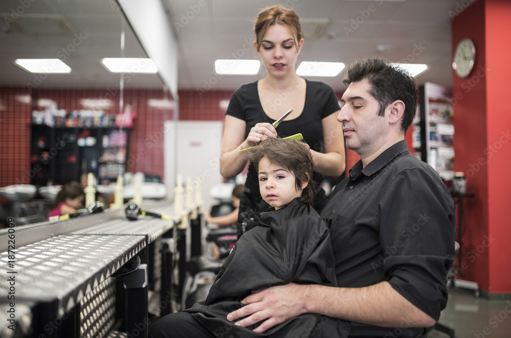Hairdresser cuts little baby hair with fathers help Hairdresser cuts little baby hair with fathers help