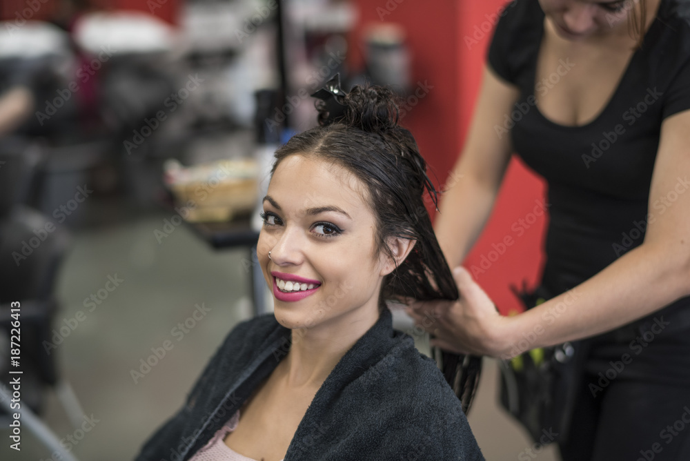 Hairdresser cuts and comb young womans hair