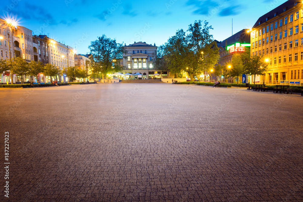Freedom Square in Poznan illuminated by street lights. In the far away theater building of the eighth day.