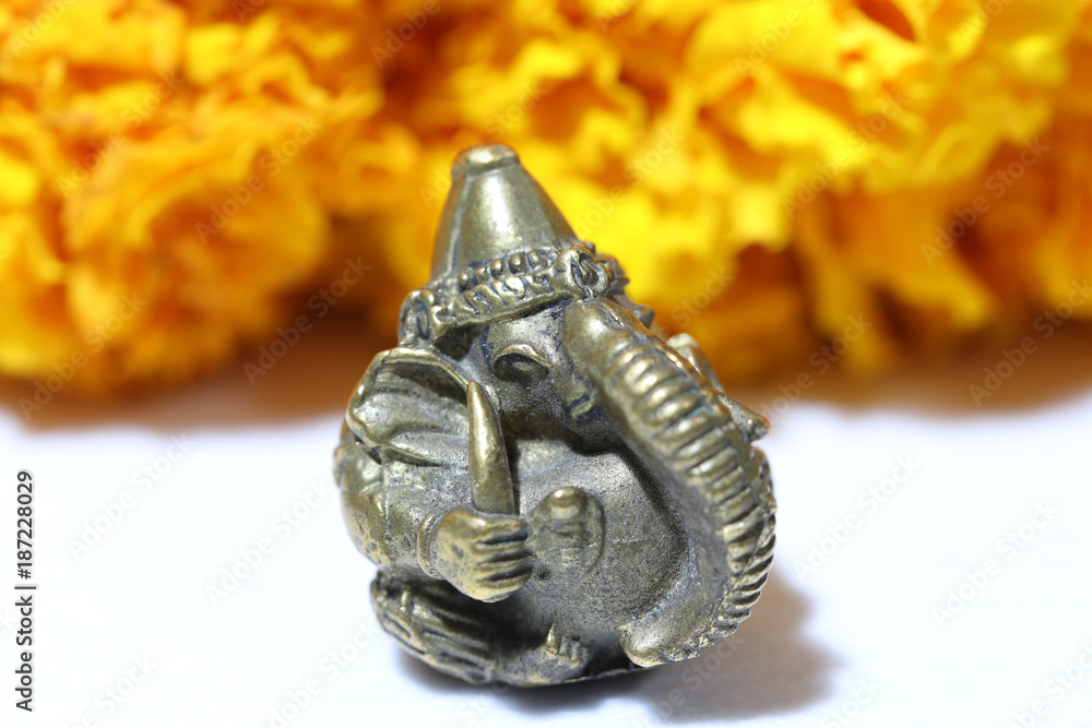 Mini Ganesha made from brass with yellow marigold flower and white