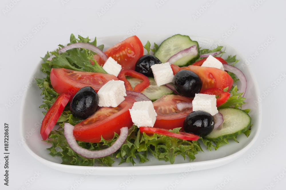 Traditional greek sallad with black olive on white plate on white background.