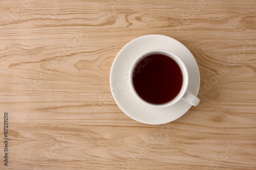 Tea in white glass on wooden floor.