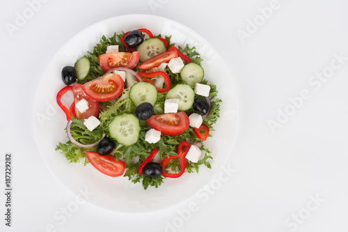 Traditional greek sallad with black olive on white plate on white background.