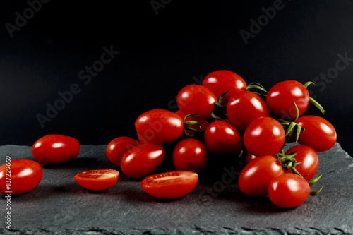 Pomodorino pachino su piatto ardesia con sfondo nero