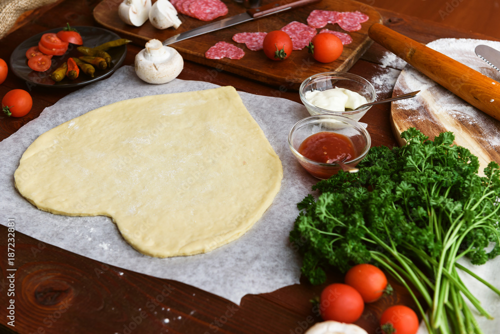 the chef makes a pizza heart for the Valentine's Day holiday. classic Italian pizza with salami and mozzarella the chef makes a pizza heart for the Valentine's Day holiday. classic Italian pizza with salami and mozzarella