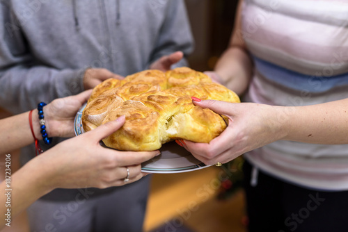 Family hands turning bread, Christmas traditions