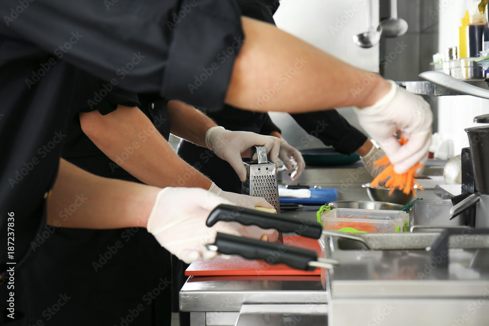Male chef cooking in restaurant kitchen, closeup Male chef cooking in restaurant kitchen, closeup