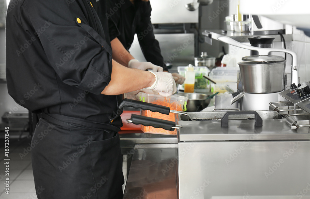 Male chef cooking in restaurant kitchen Male chef cooking in restaurant kitchen