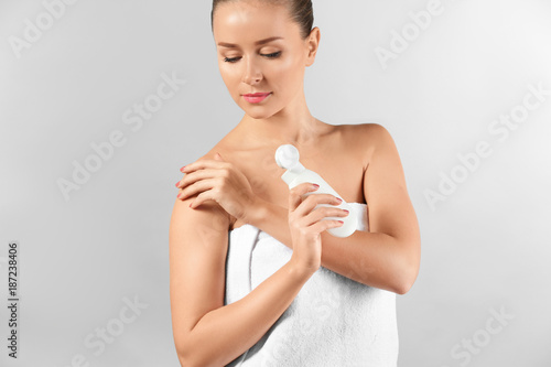 Young woman applying body c...