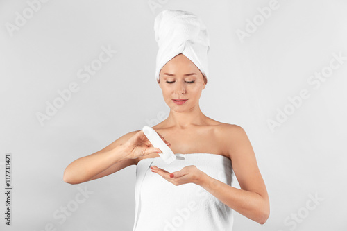 Young woman applying body c...