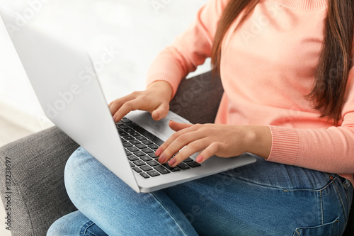 Young woman working on laptop at home, closeup