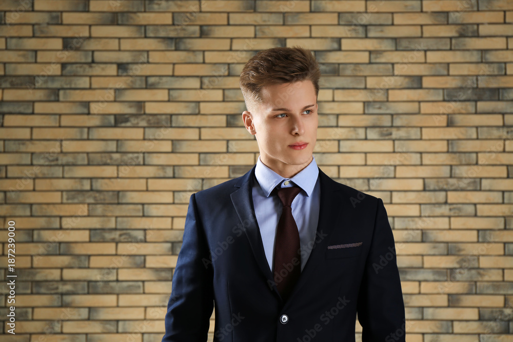 Handsome man in formal suit against brick wall Handsome man in formal suit against brick wall