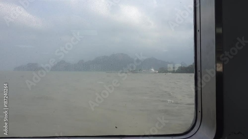 big waves on the sea on a cloudy day. View from a dirty ferry window, Thailand