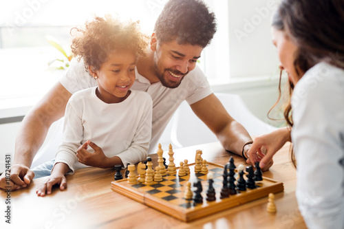 Happy family playing chess together