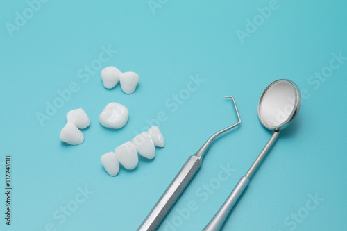 Dental tools and Tooth implant on a Turquoise background