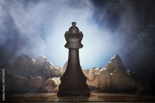 Victory in chess. Queen in front and many dead pieces in background. 3D rendered illustration.