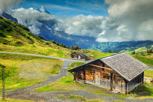 Typical Swiss alpine farmhouses and snowy mountains, Bernese Oberland, Switzerland
