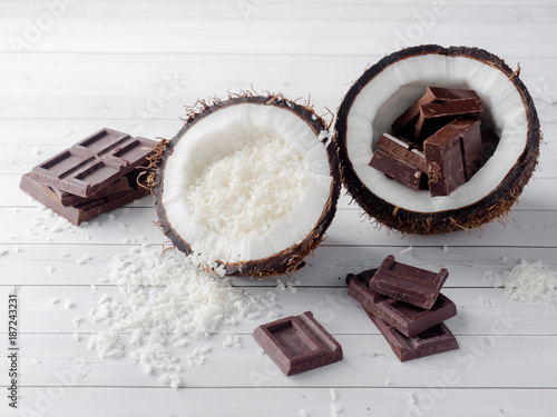 Fresh organic coconut broken into two parts with chocolate on a rustic wooden background