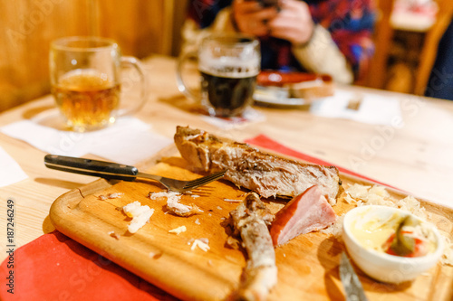 Crafted czech mug of beer and traditional sausage and pork meat on a white plate in bar or restaurant