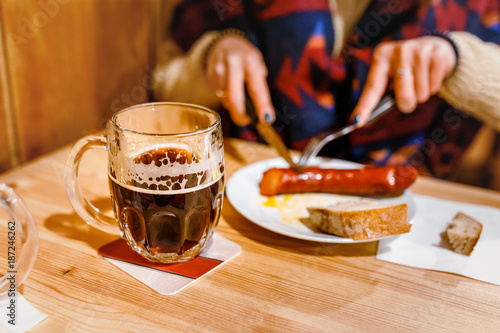 Photography Crafted czech mug of beer and traditional sausage and pork meat on a white plate