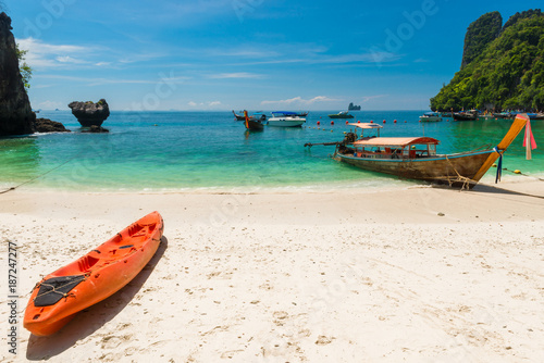 kayak and wooden Thai boats off the coast of Hong Island, Thailand