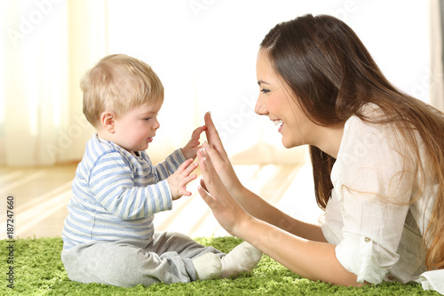 Mother playing with her baby on a carpet