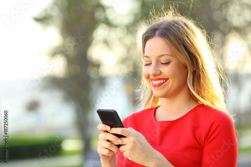 Girl in red texting in a smart phone outside