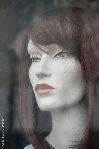 mannequin  avec perruque dans une vitrine de coiffeur