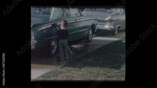 1963 3 year old Little boy washes antique car