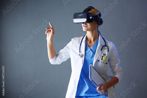 Female doctor wearing virtual reality glasses isolated on white background.