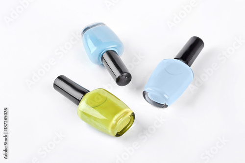 Three multicolored nail polish. Blue, light blue and yellow nail varnish isolated on white background.