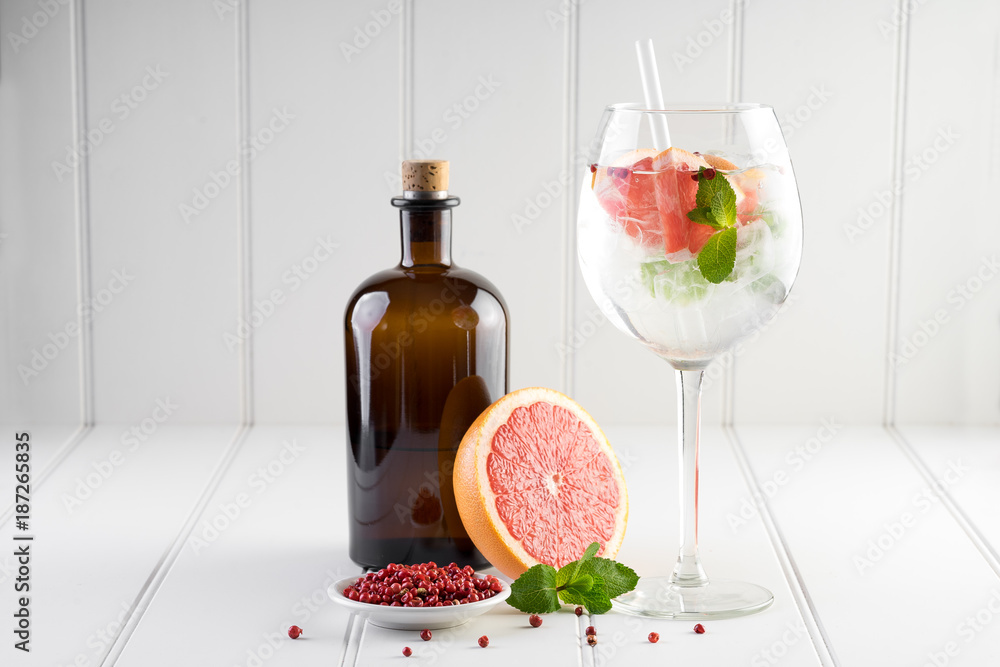 gin and tonic alcohol drink cocktail glass ice fruit garnish plain black white background