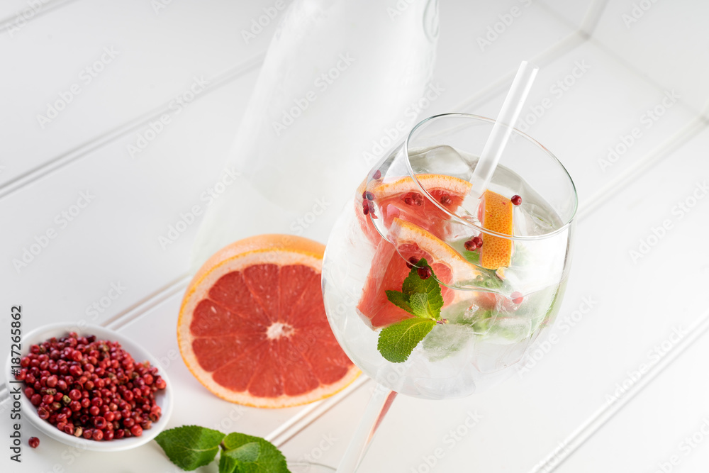 gin and tonic alcohol drink cocktail glass ice fruit garnish plain black white background