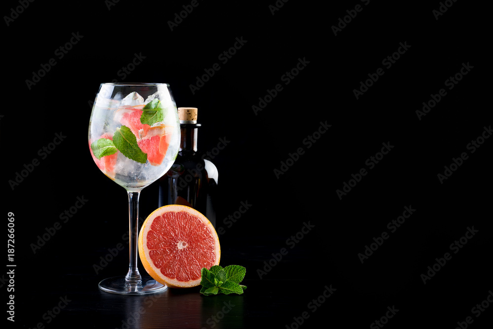 gin and tonic alcohol drink cocktail glass ice fruit garnish plain black white background