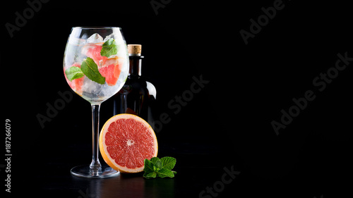 Obraz na płótnie gin and tonic alcohol drink cocktail glass ice fruit garnish plain black white background w salonie