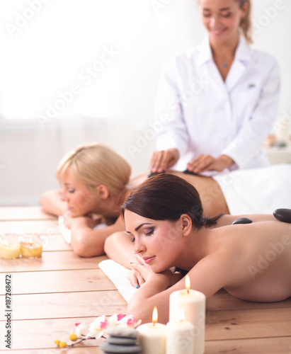 Two young beautiful women relaxing and enjoying at the spa center