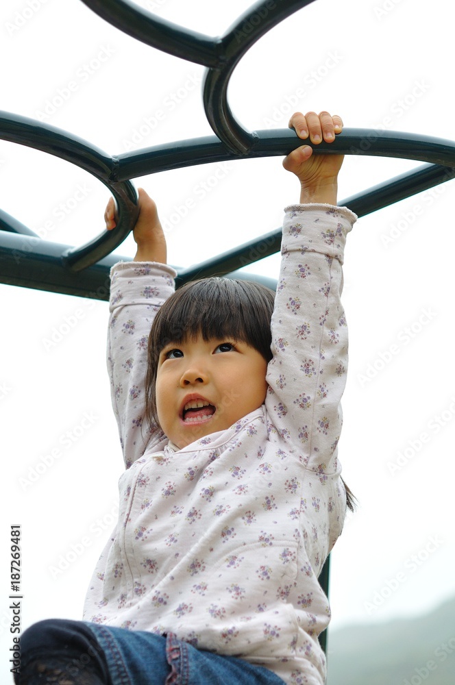 Obraz premium 公園の遊具で遊ぶ女の子