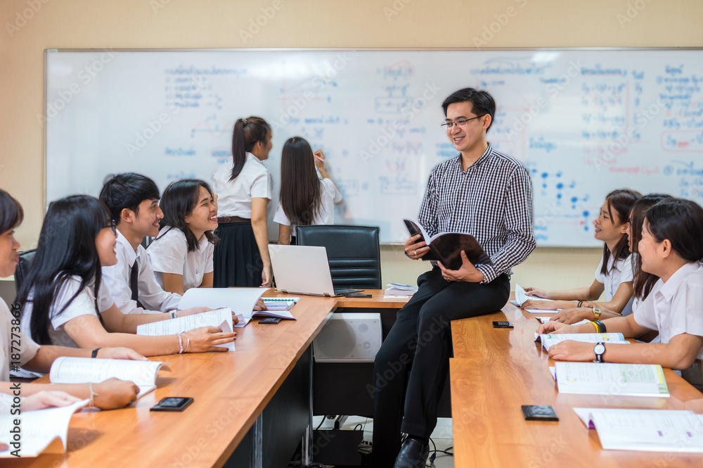 Asian teacher Giving Lesson to group of College Students in the classroom, University education concept Asian teacher Giving Lesson to group of College Students in the classroom, University education concept