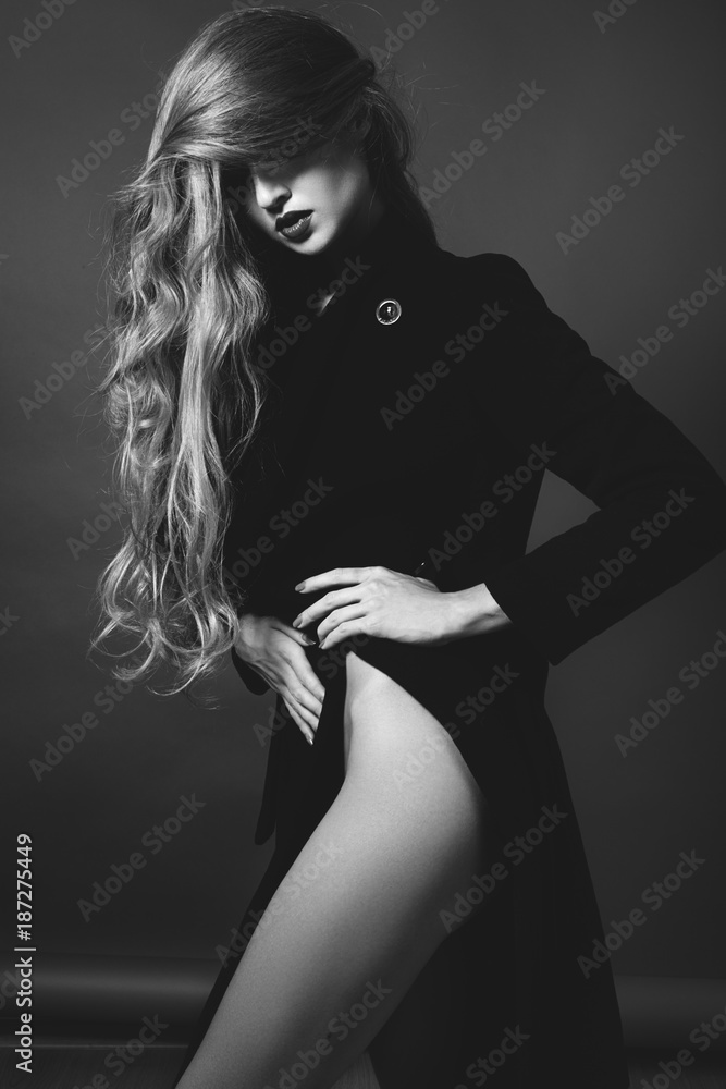 Sexy lady in Elegant Coat. Beautiful model in Fashion Jacket with Long Curly Hair. Erotic style. Black and White shot Sexy lady in Elegant Coat. Beautiful model in Fashion Jacket with Long Curly Hair. Erotic style. Black and White shot