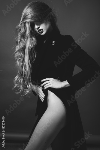 Sexy lady in Elegant Coat. Beautiful model in Fashion Jacket with Long Curly Hair. Erotic style. Black and White shot