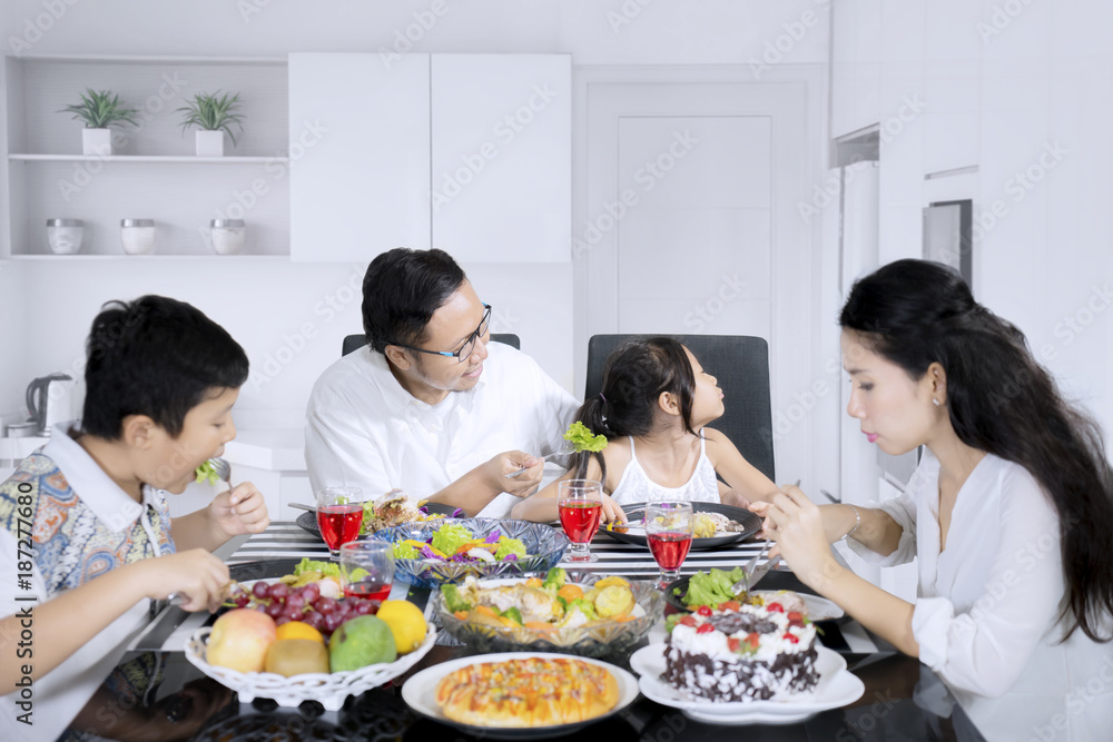 Child refusing to eat salad in the kitchen Child refusing to eat salad in the kitchen