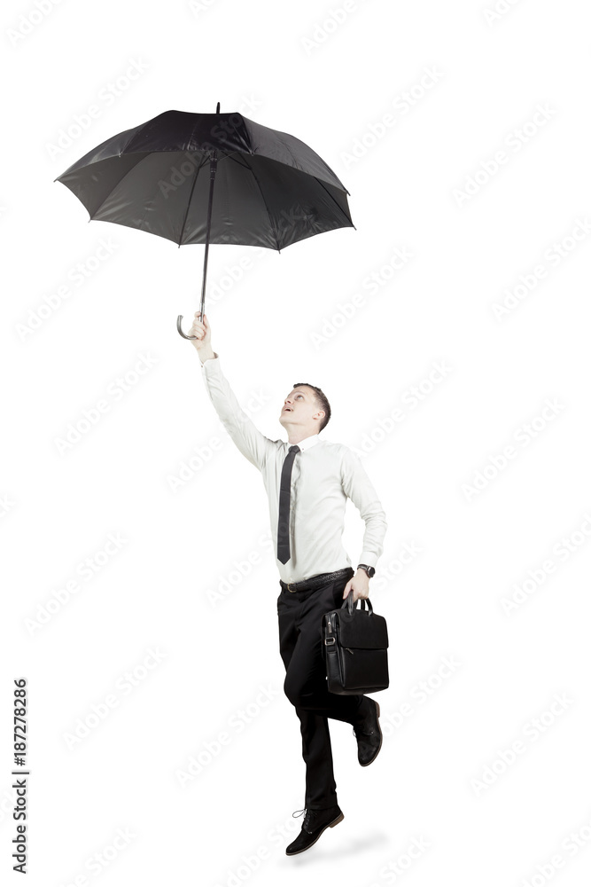 Caucasian businessman flying with an umbrella on studio Caucasian businessman flying with an umbrella on studio