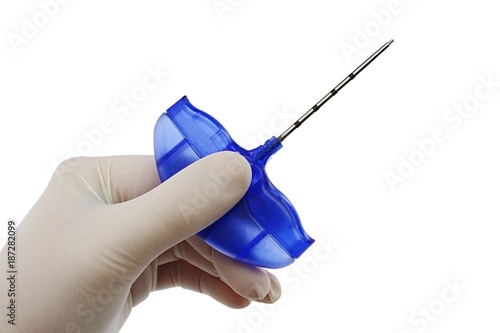 Photos Bone marrow biopsy needle held in doctor left hand in sterile powdered latex glo