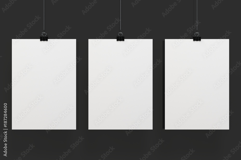 Three blank white posters with binder clip mockup on black background Three blank white posters with binder clip mockup on black background