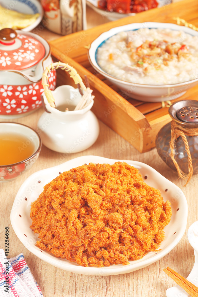 Dried shredded pork (or pork floss) with tea and gruel  on wooden table     