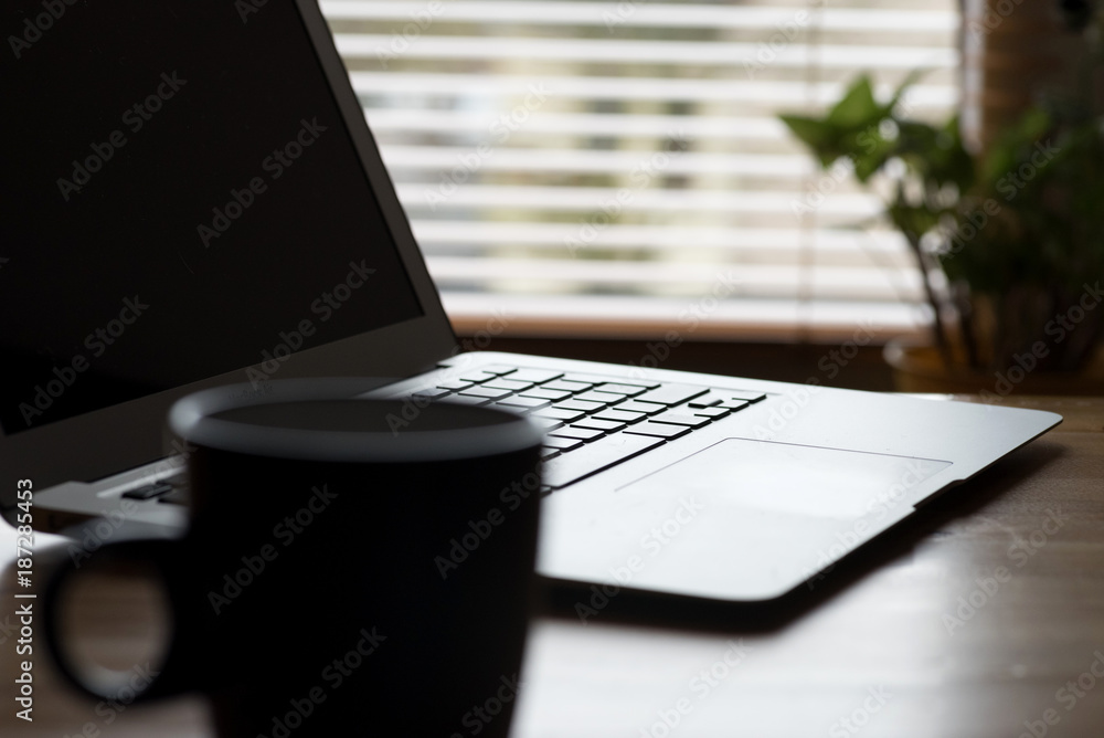 Fototapeta premium Ein Laptop und eine Kaffeetasse auf einem Tisch im Büro