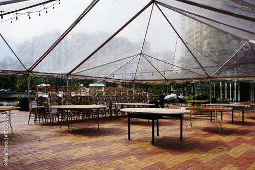 Clear Tent Event Setup with Stacked Chairs in Urban Setting