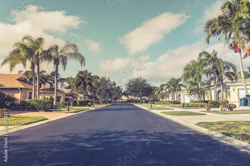 Asphalt road through gated community subdivision, South Florida. Vintage colors © marchello74